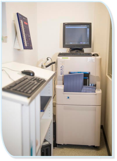 Eine Röntgeneinheit mit einem Computerbildschirm und einer Tastatur in einem medizinischen Raum.