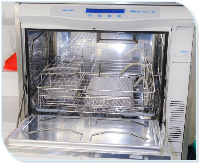 Das geöffnete Innere eines Desinfektors, der Metallkörbe zur Aufnahme von medizinischen Instrumenten enthält.